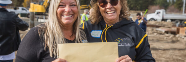 (L) Beth Stipe, CFNCW Executive Director and (R) Nancy Nash-Méndez, HAOC Executive Director, hold the ARC loan repayment check during the groundbreaking for the Wildrose Multifamily Affordable Housing project in Winthrop, WA.