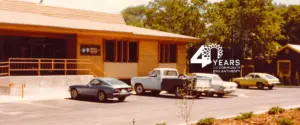 Archival scan of original CFNCW building from 1986 with cars parked out front