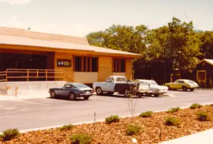Archival scan of original CFNCW building from 1986 with cars parked out front
