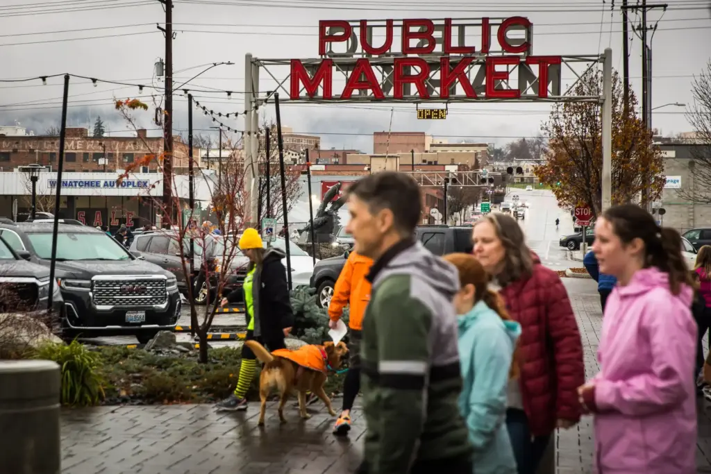 Runners at the Give NCW Turkey Trot walk past the iconic Pybus Public Market sign